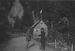 Miejsce przejściowe po drogach ulicznych, funkcjonariusz Straży Celnej kontroluje dokumenty na przejściu granicznym. W tle z lewej Skały Rygle Sokolicy (1927)