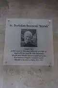 Tablica upamiętniająca ks. Bronisława Bozowskiego na furtce, na zewnątrz oficyny sióstr wizytek od strony ulicy Karowej w Warszawie