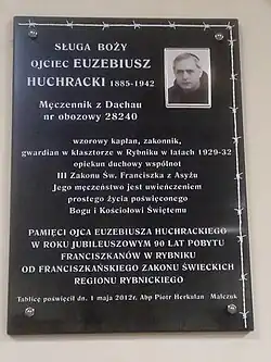Tablica upamiętniająca Sługę Bożego ojca Euzebiusza Huchrackiego OFM, poświęcona w Rybniku w maju 2012 przez arcybiskupa Piotra Herkulana Malczuka OFM