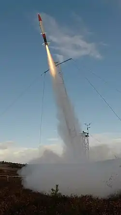 Fotografia rakiety wznoszącej się ponad wyrzutnię