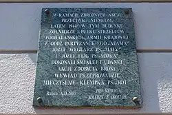 Tablica na ścianie budynku upamiętniająca historię obiektu w latach II wojny światowej