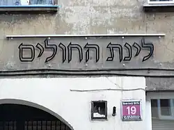 Zabytkowy napis, zabezpieczony ochronną płytą z nadrukiem. Znajduje się pod numerem 19.