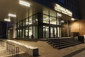 Zdjęcie wejścia do budynku. Jest noc, widać świecący się neon Biblioteka Wojewódzka.