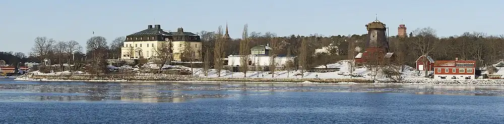 Widok na kompleks Waldemarsudde: po lewej budynek główny i mniejszy, biały budynek galerii po prawej; dalej na prawo budynek tłoczni oleju (wiatrak) i oranżeria