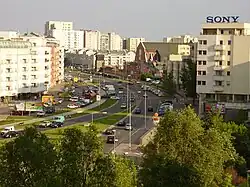 Aleja Komisji Edukacji Narodowej na terenie osiedla z widocznym po prawej kościołem Wniebowstąpienia Pańskiego