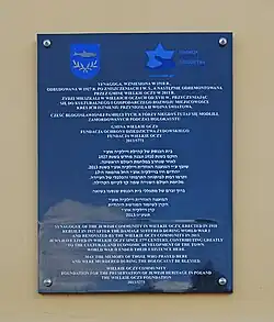 Tablica pamiątkowa na ścianie frontowej